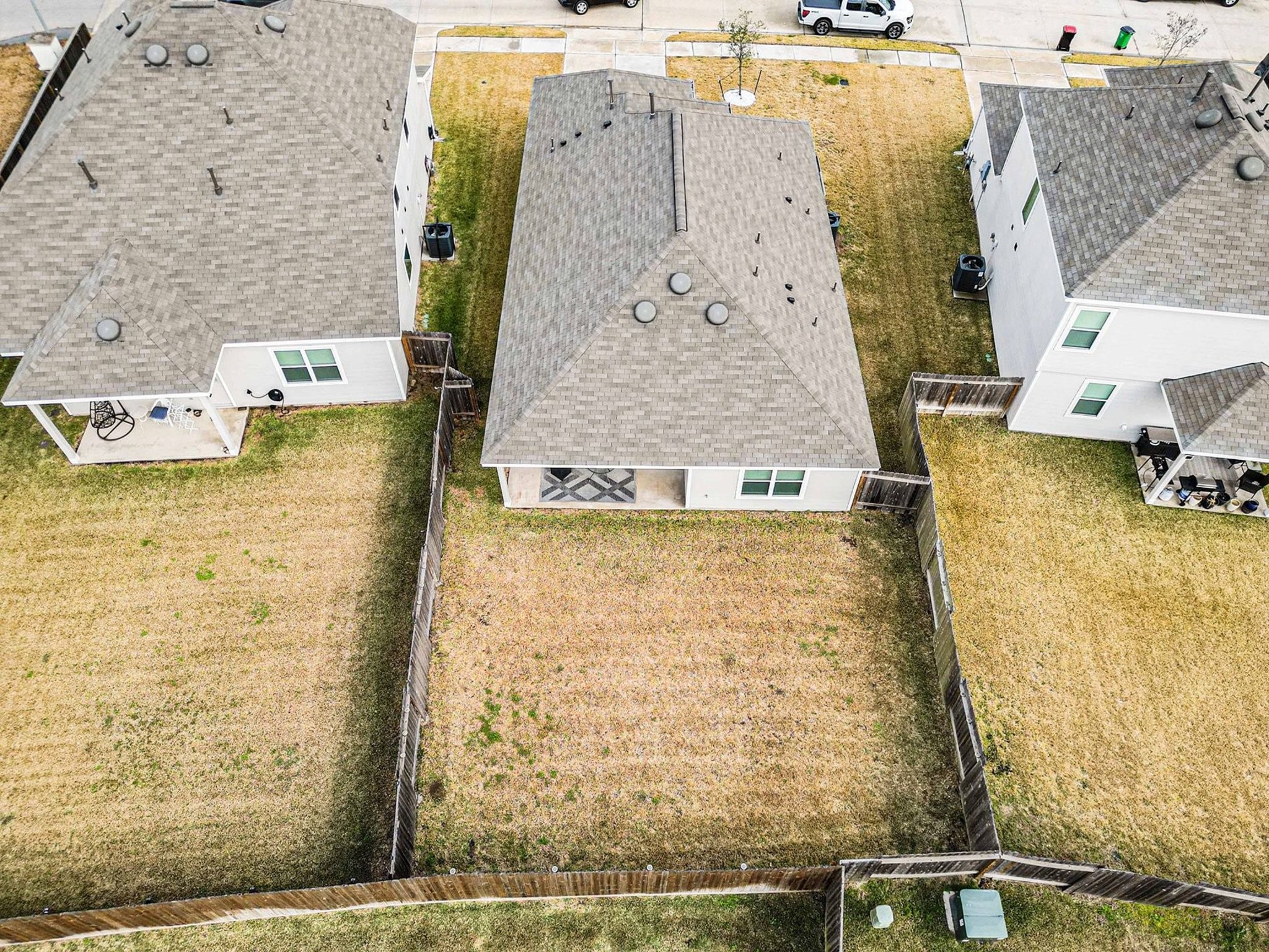 4906 Luke Matthew Drive Rosharon, TX 77583 - Photo 28 of 34 This aerial photo shows a single-story home with a fenced backyard. The house has a light-colored roof and exterior, and it's situated in a suburban neighborhood with similar houses nearby. The yard offers ample space and privacy.