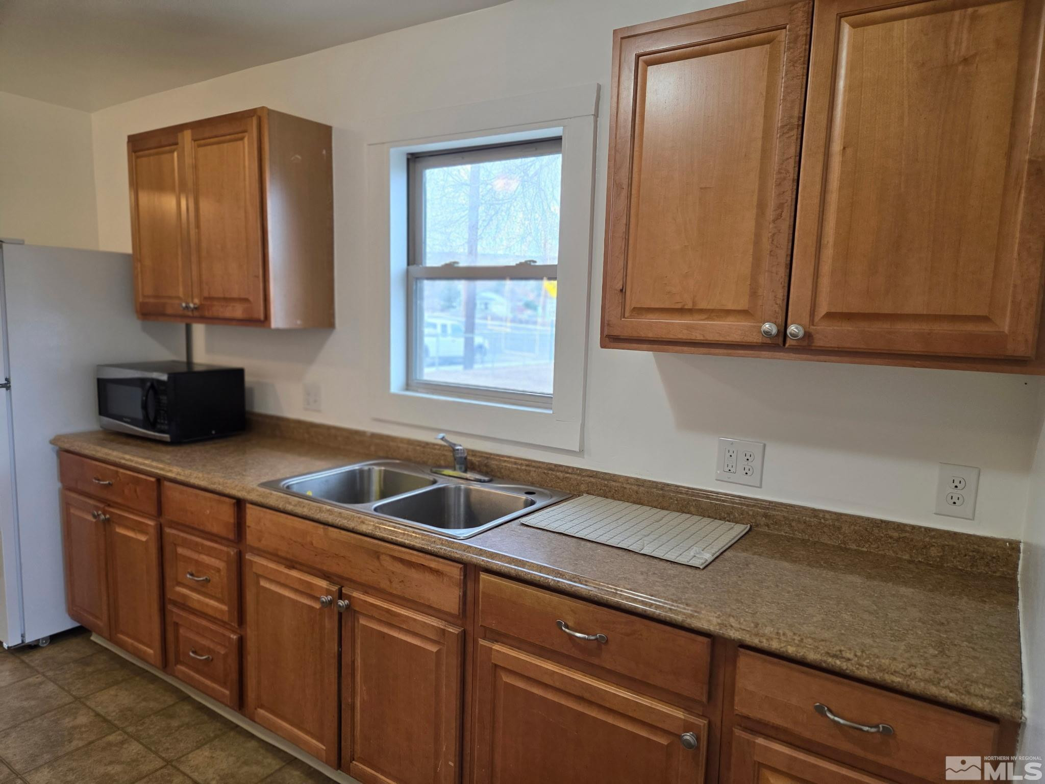 1810 Montello Street Reno, NV 89512 - Photo 7 of 22 a kitchen with granite countertop a sink and a wooden cabinets