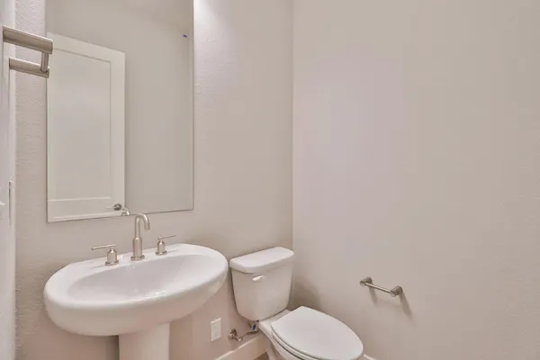 a bathroom with a sink a toilet and mirror