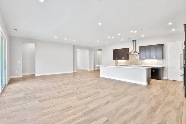 a view of kitchen with kitchen island granite countertop a sink and cabinets