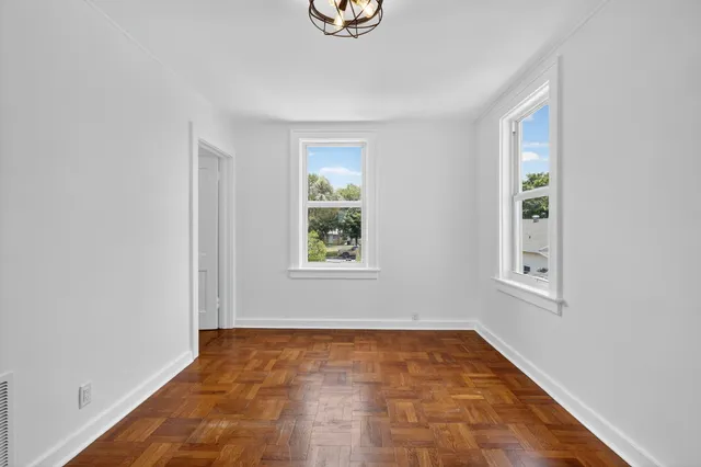 a view of an empty room with wooden floor