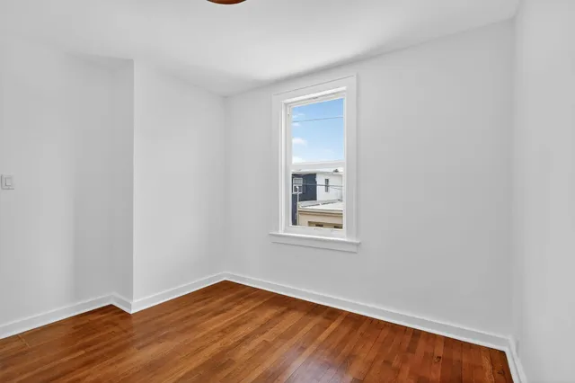a bedroom with bed and wooden floor