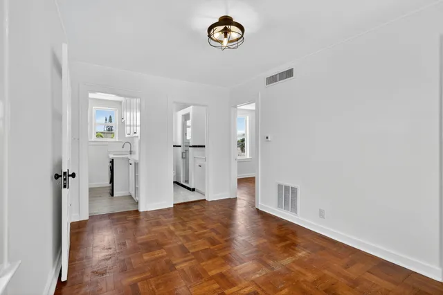a view of a room with wooden floor and a window
