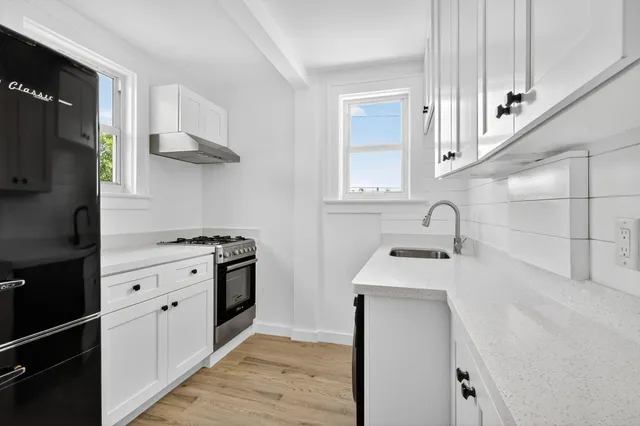 a kitchen with stainless steel appliances granite countertop a sink stove and cabinets