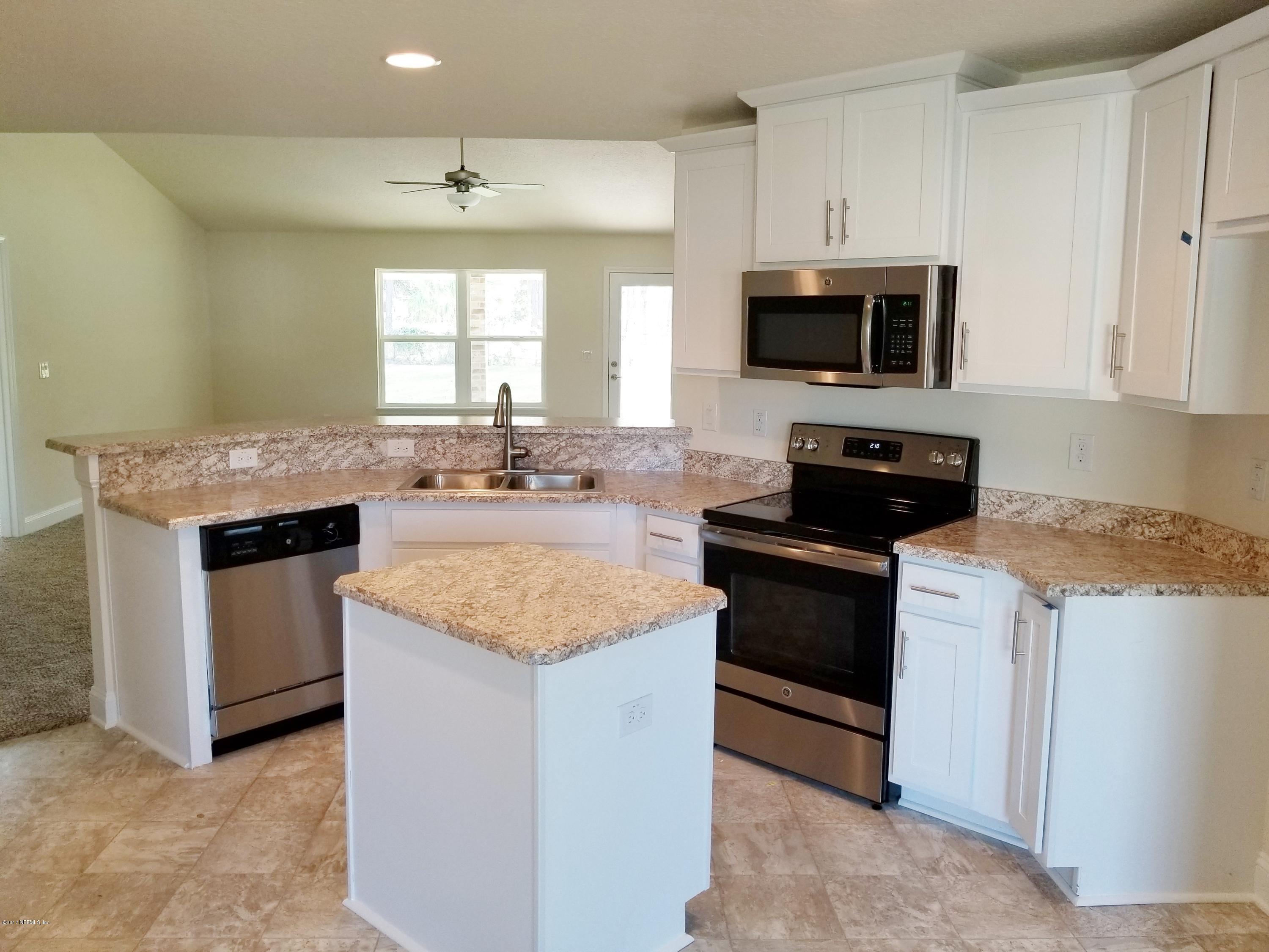 88051 Maybourne Road Yulee, FL 32097 - Photo 15 of 22 a kitchen with stainless steel appliances granite countertop a sink stove and microwave