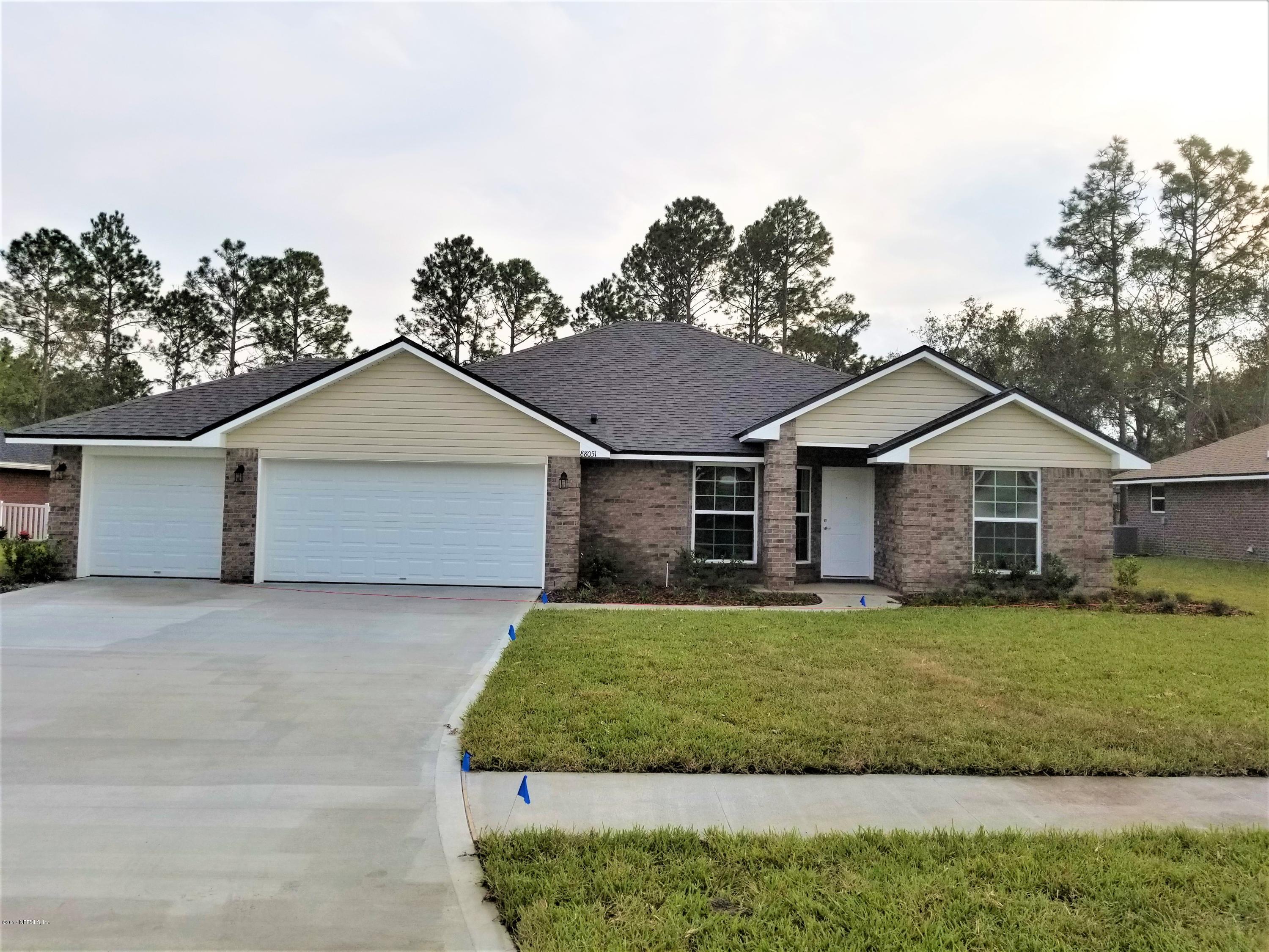 88051 Maybourne Road Yulee, FL 32097 - Photo 2 of 22 a front view of a house with a yard