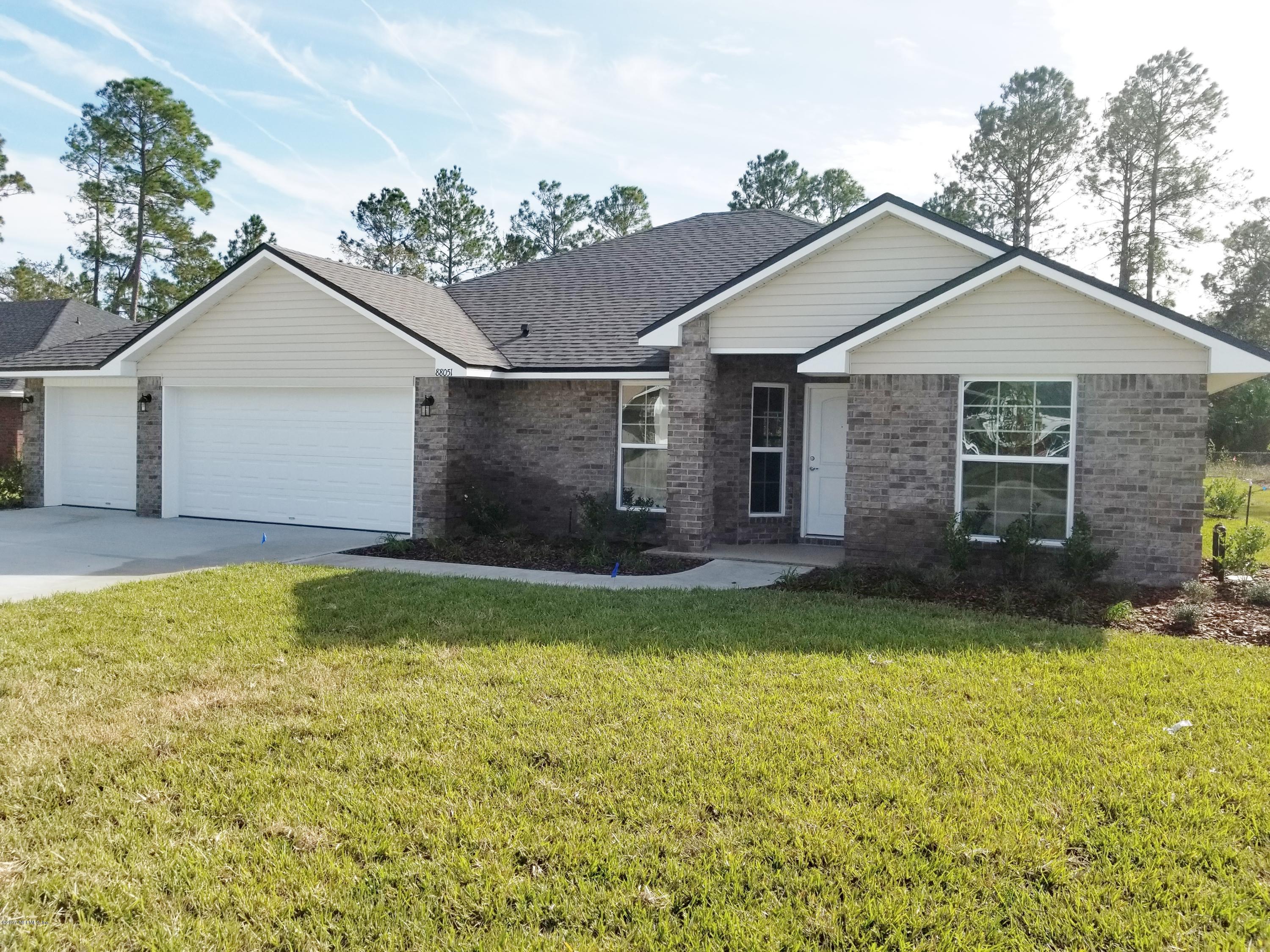 88051 Maybourne Road Yulee, FL 32097 - Photo 3 of 22 a view of a house with a yard and garage