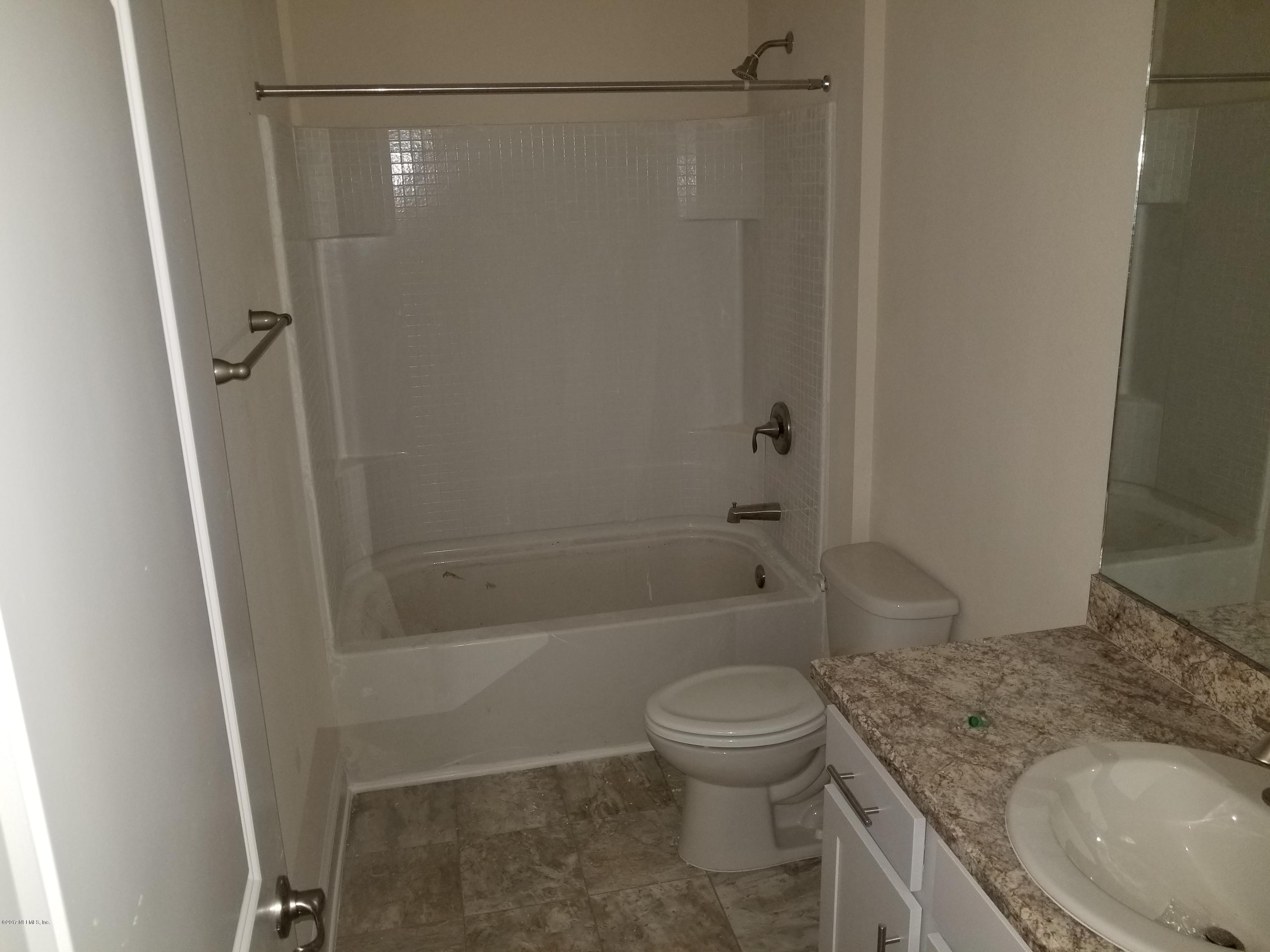 88051 Maybourne Road Yulee, FL 32097 - Photo 7 of 22 a bathroom with a granite countertop bathtub shower sink vanity and toilet