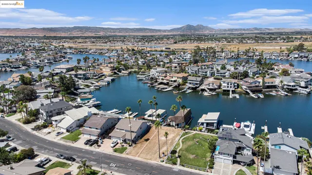 an aerial view of a city with lots of residential buildings ocean and mountain view in back