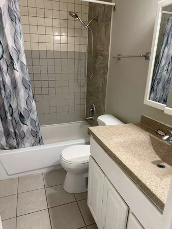 a bathroom with a granite countertop toilet a sink and bathtub
