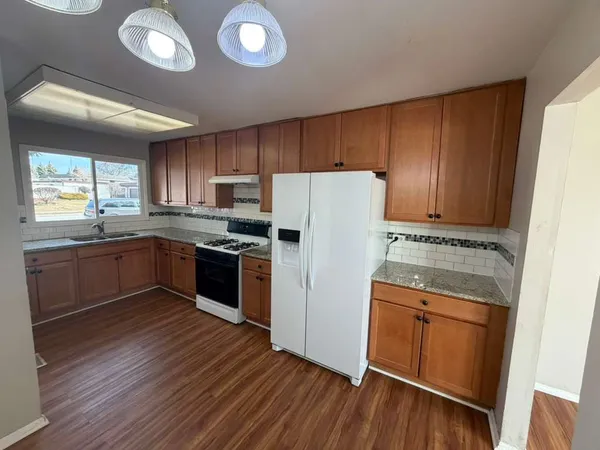 a kitchen with a refrigerator sink and cabinets