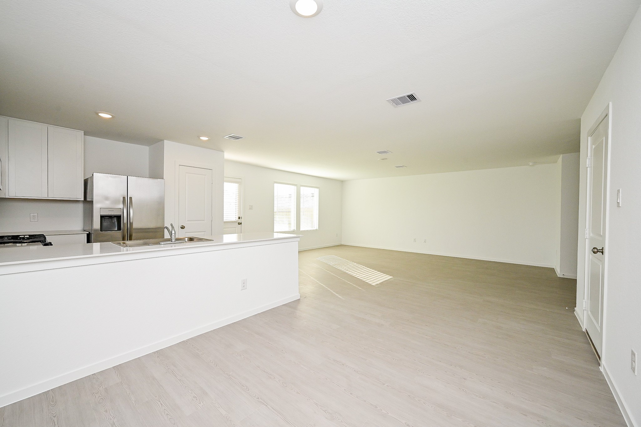 6818 Flowering Ginger Lane Katy, TX 77493 - Photo 24 of 47 a large kitchen with kitchen island a sink wooden floor and white stainless steel appliances