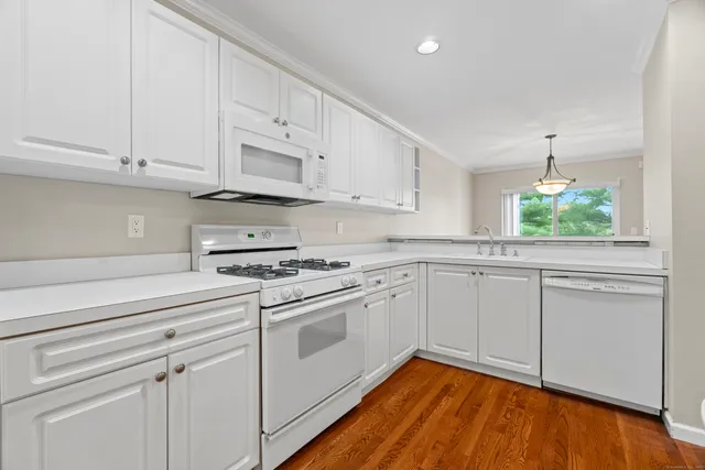 a kitchen with granite countertop white cabinets and white appliances