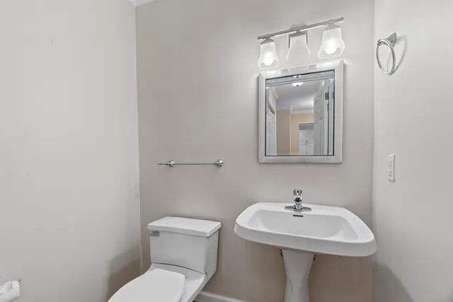 a bathroom with a toilet a sink and mirror