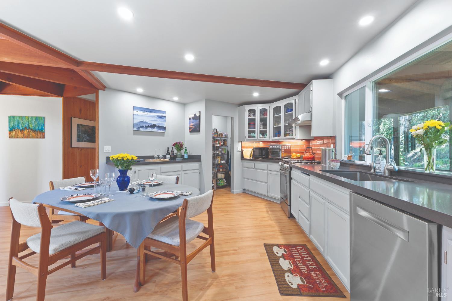 9085 Middle Terrace Monte Rio, CA 95462 - Photo 15 of 77 a kitchen with stainless steel appliances granite countertop table chairs sink and cabinets