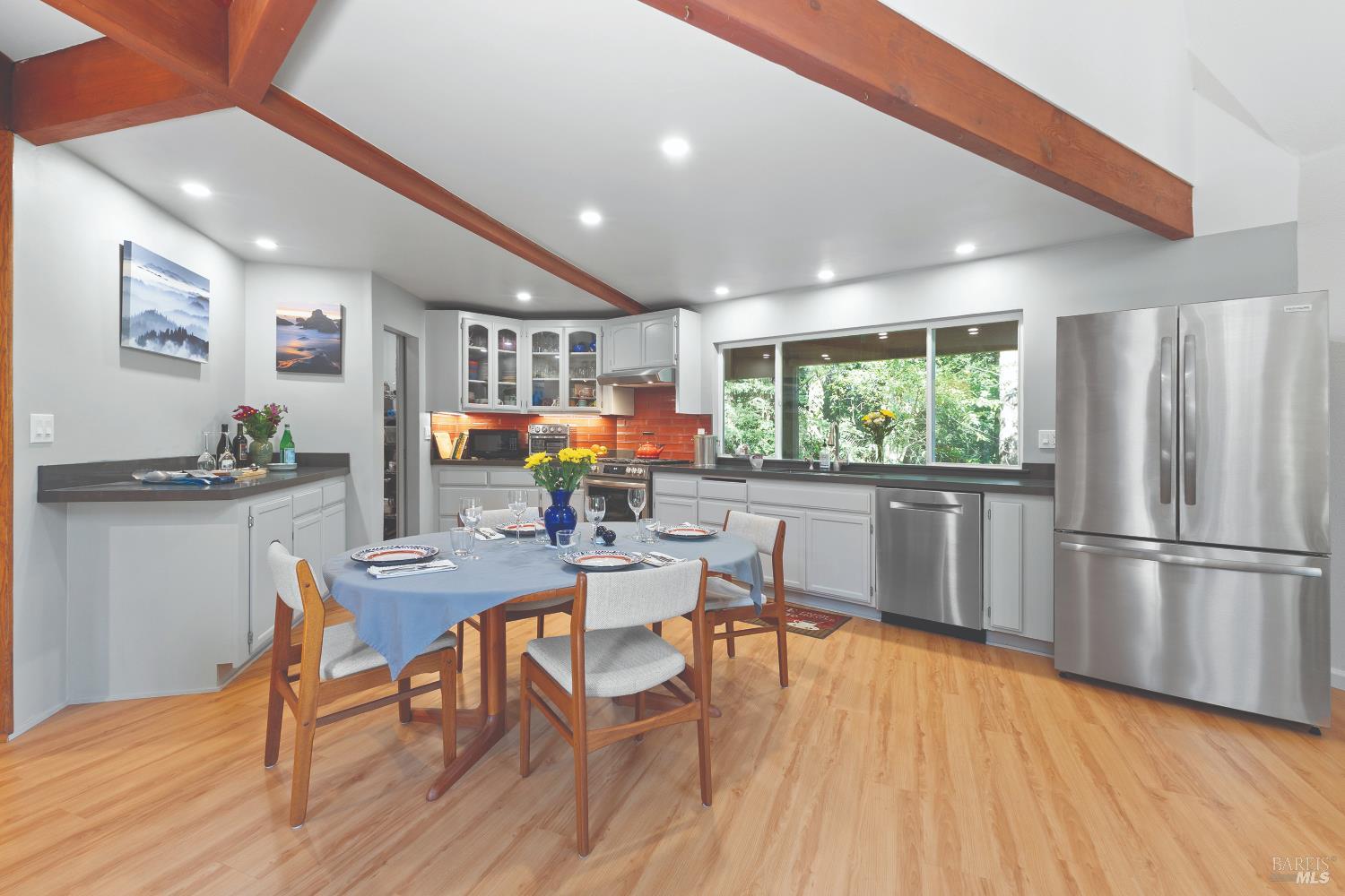 9085 Middle Terrace Monte Rio, CA 95462 - Photo 5 of 52 a kitchen with stainless steel appliances granite countertop a refrigerator a microwave oven a dining table and chairs with wooden floor