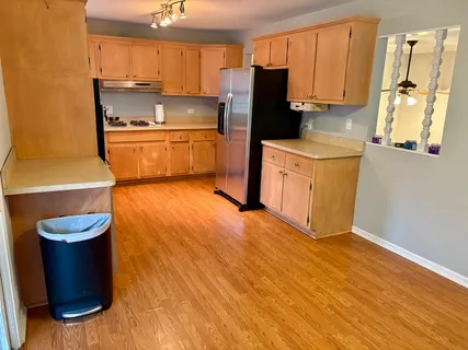 a kitchen with a refrigerator sink and wooden cabinets