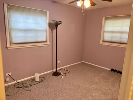 an empty room with a chandelier fan and closet