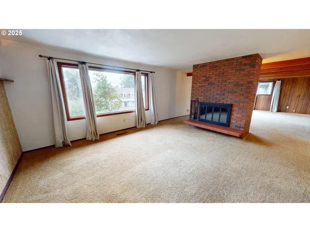 a living room with a fireplace furniture and a large window
