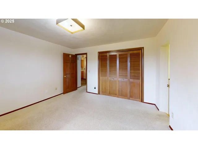 a open hall with a ceiling fan and window