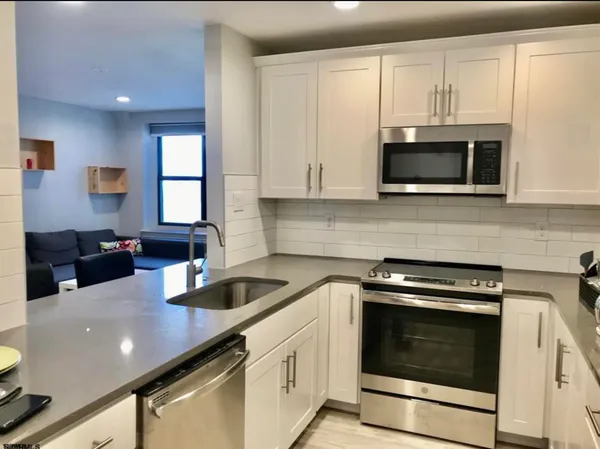 a kitchen with stainless steel appliances a stove microwave and sink