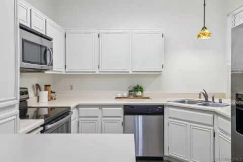 a kitchen with stainless steel appliances granite countertop a sink and a stove