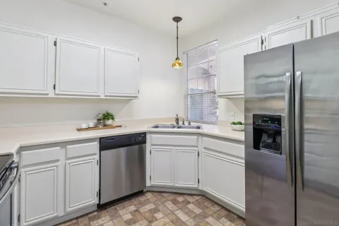 a kitchen with white cabinets and refrigerator