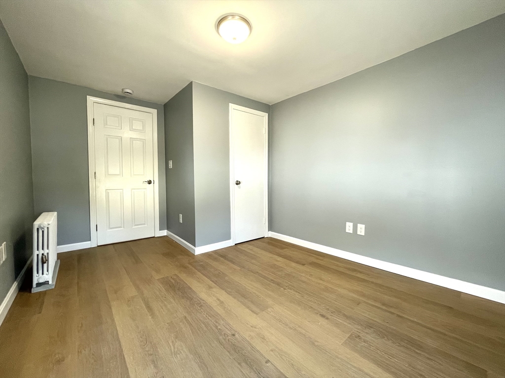 46-52 Main Street, Unit 2R Framingham, MA 01702 - Photo 3 of 7 an empty room with wooden floor and windows
