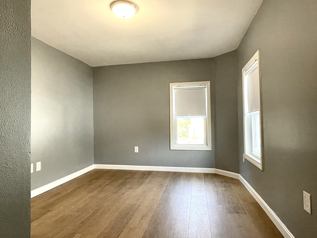 46-52 Main Street, Unit 2R Framingham, MA 01702 - Photo 4 of 7 an empty room with wooden floor and windows