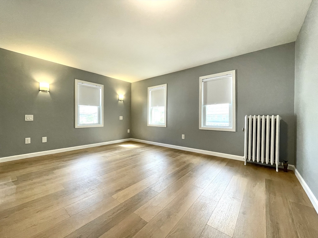 46-52 Main Street, Unit 2R Framingham, MA 01702 - Photo 7 of 7 an empty room with wooden floor and windows