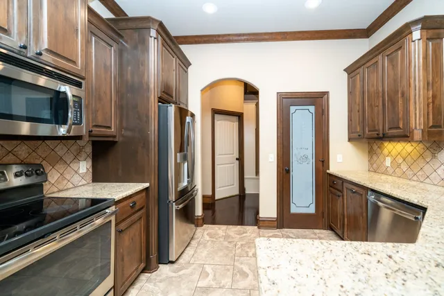 a kitchen with stainless steel appliances granite countertop a stove a refrigerator and a sink