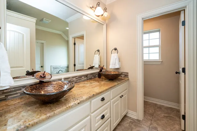 a bathroom with a granite countertop sink and a mirror
