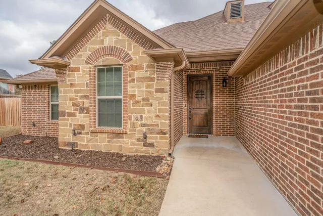 a view of a brick house with large windows
