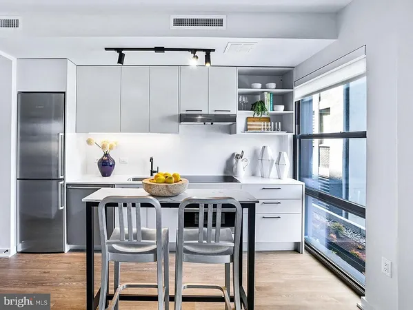 a kitchen with stainless steel appliances granite countertop a stove a refrigerator and a dining table