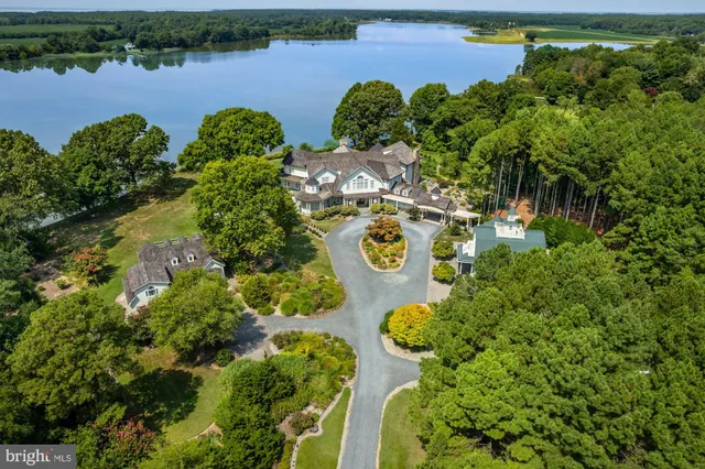 an aerial view of a residential houses with outdoor space and lake view