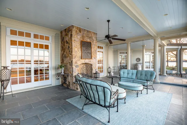 a living room with furniture a fireplace and a large window