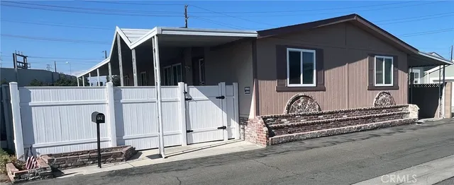 a view of a house with a barbeque and wooden fence