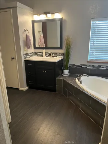 a spacious bathroom with a granite countertop sink and a mirror