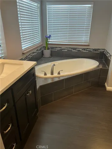 a spacious bathroom with a bathtub and a sink