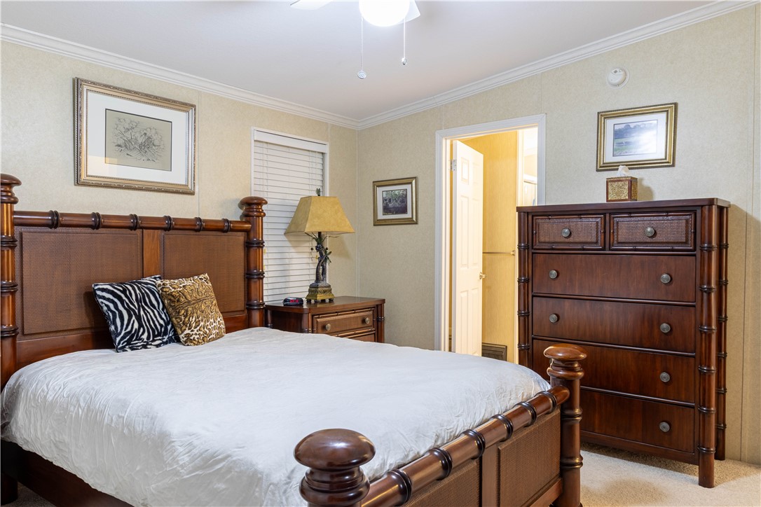 6171 98th Road Sebastian, FL 32958 - Photo 17 of 35 a bedroom with a bed and a chandelier