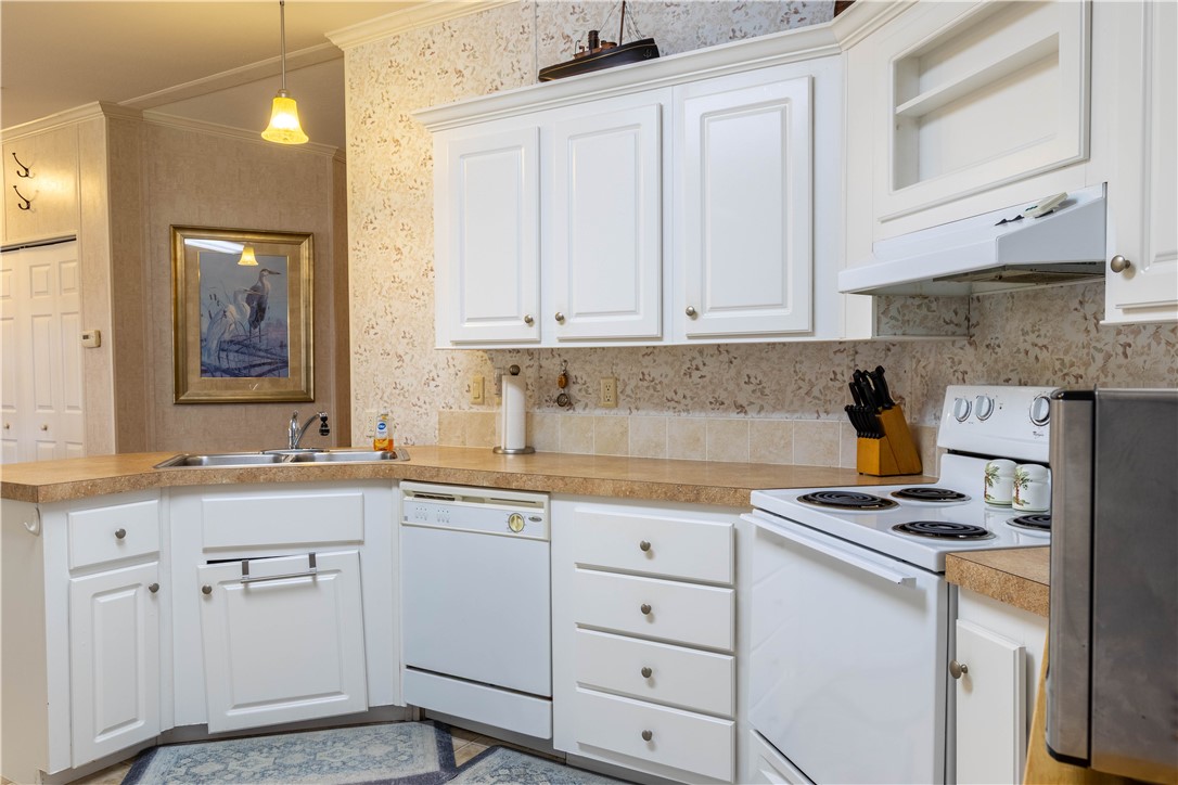 6171 98th Road Sebastian, FL 32958 - Photo 6 of 35 a kitchen with white cabinets and appliances