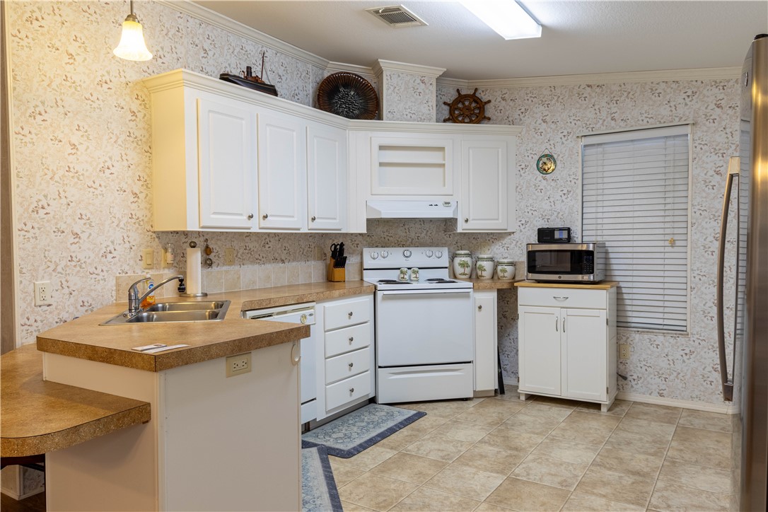 6171 98th Road Sebastian, FL 32958 - Photo 9 of 35 a kitchen with a white cabinets and white appliances