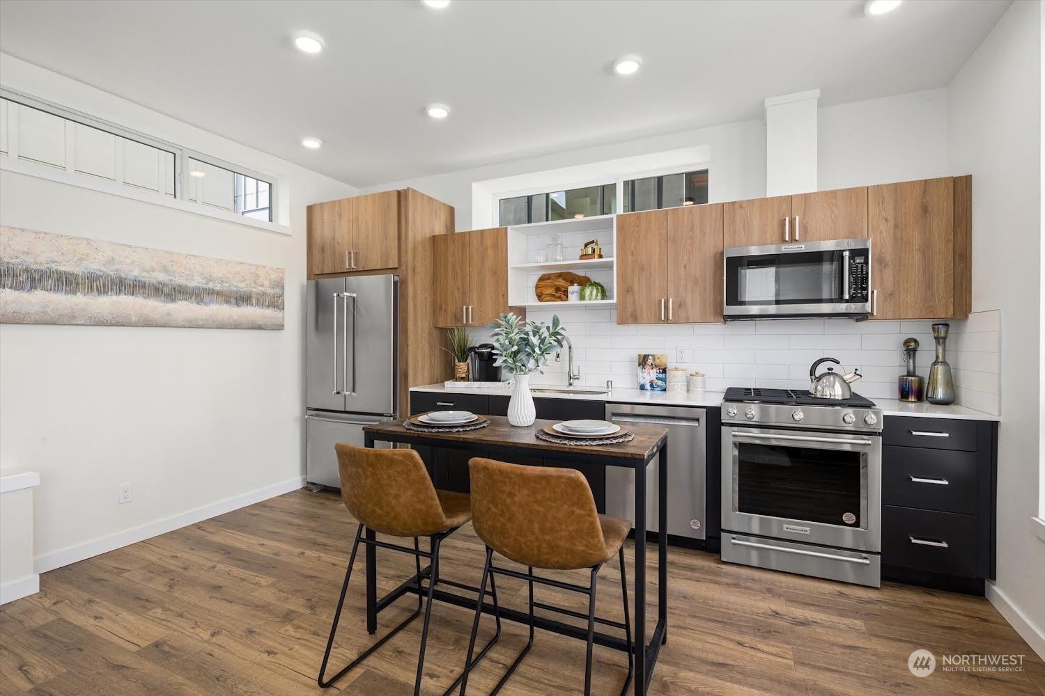 2203 22nd Avenue South Seattle, WA 98144 - Photo 11 of 21 a kitchen with stainless steel appliances granite countertop a stove a sink a microwave a refrigerator white cabinets and wooden floor