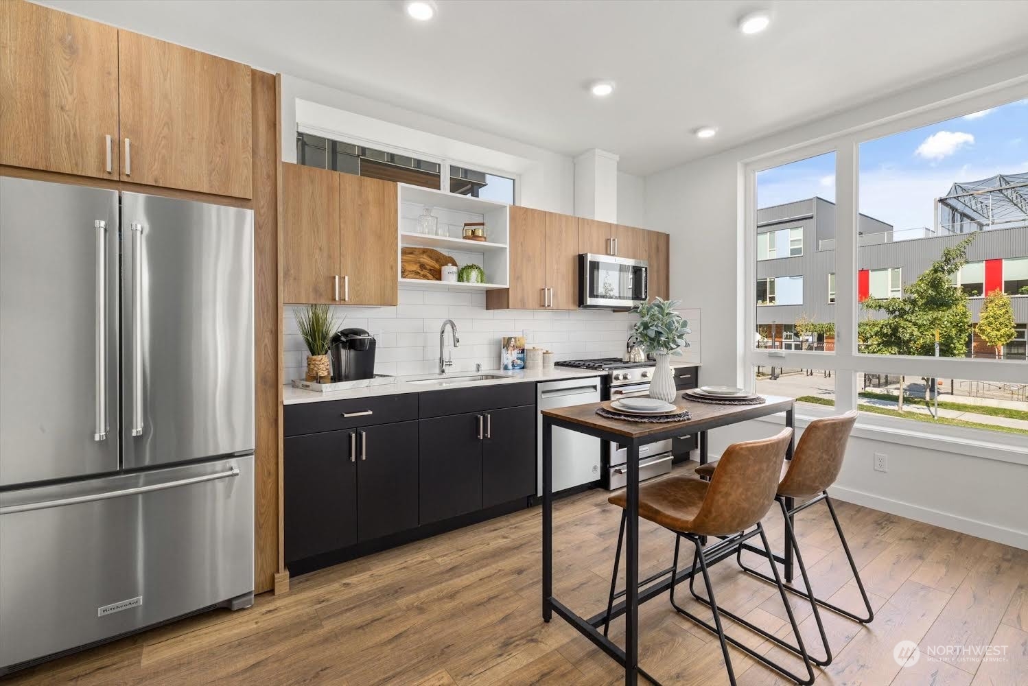 2203 22nd Avenue South Seattle, WA 98144 - Photo 8 of 21 a kitchen with stainless steel appliances granite countertop a refrigerator a sink dishwasher a dining table and chairs with wooden floor