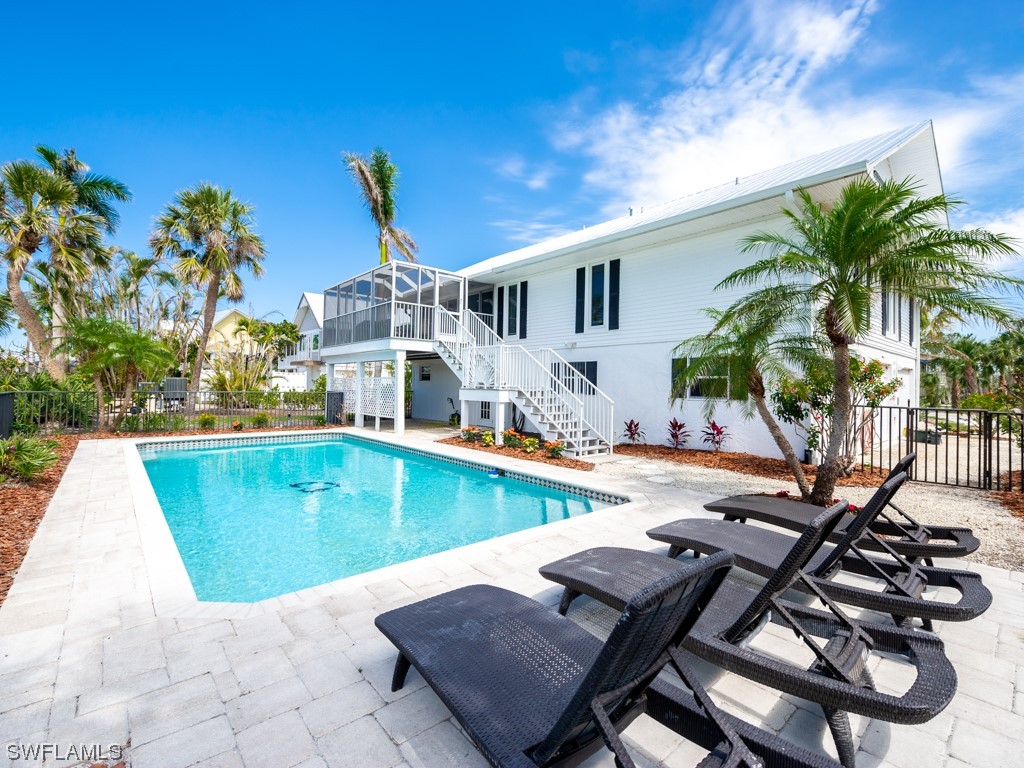1015 Sand Castle Road Sanibel, FL 33957 - Photo 3 of 42 a view of a swimming pool with chair and table
