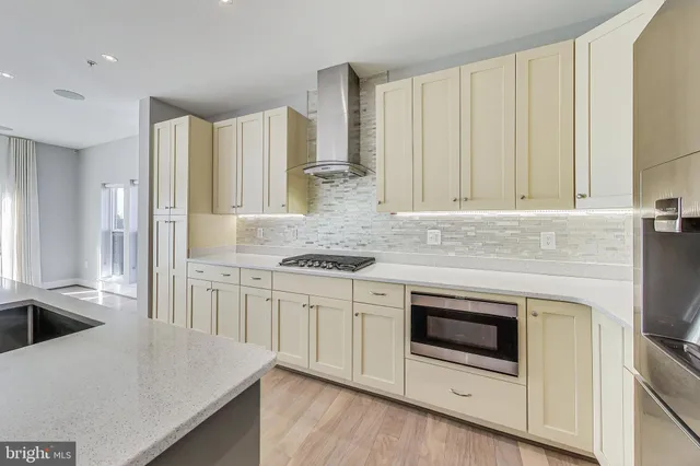 a kitchen with stainless steel appliances granite countertop a stove a sink and a refrigerator