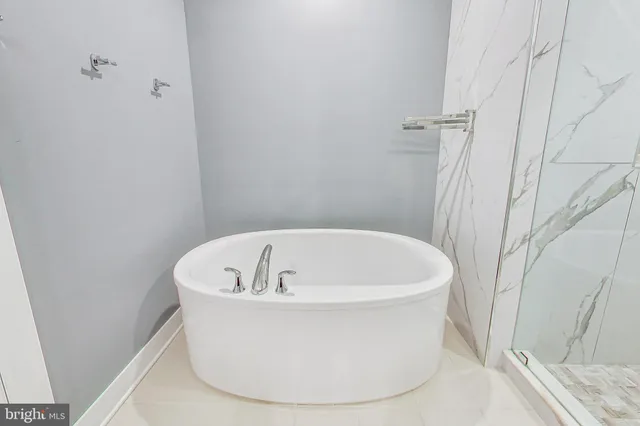 a bathroom with a granite countertop sink a toilet a mirror and bathtub