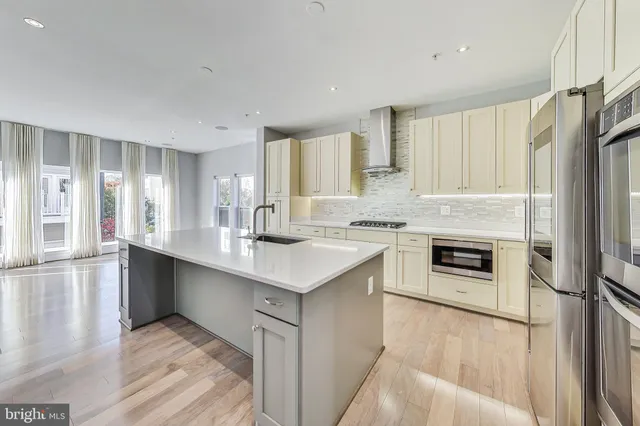 a kitchen with stainless steel appliances granite countertop a refrigerator a stove and a sink