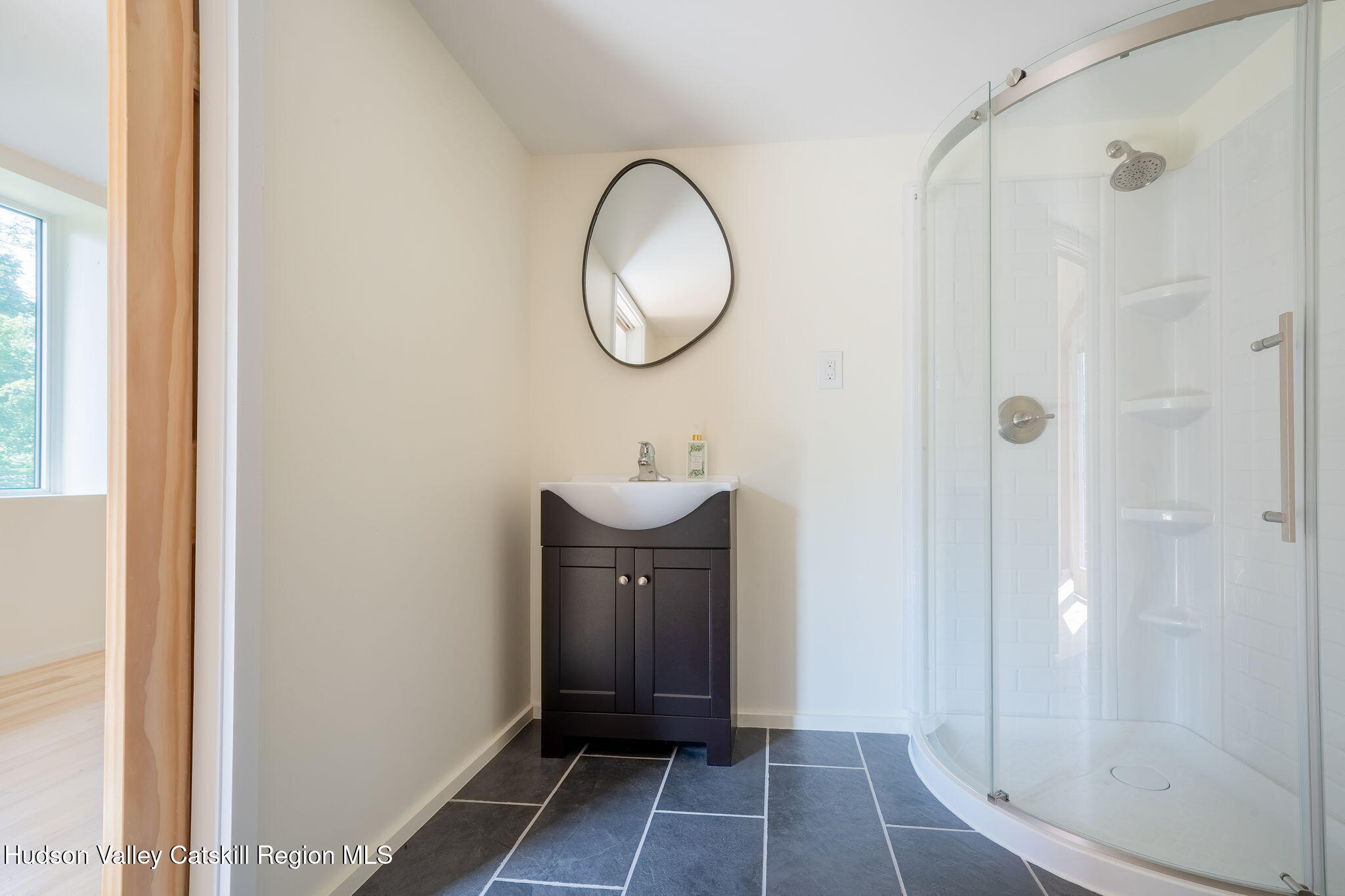 10 Harry Wells Road Saugerties, NY 12477 - Photo 18 of 58 a bathroom with a sink a mirror and a shower