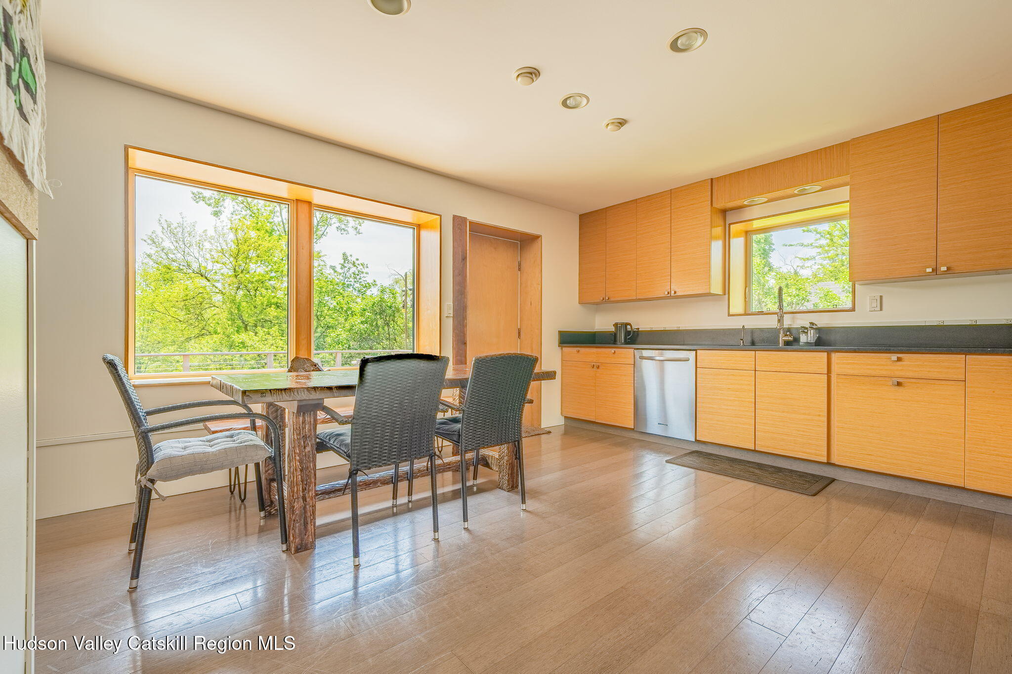 10 Harry Wells Road Saugerties, NY 12477 - Photo 31 of 58 a kitchen with stainless steel appliances granite countertop a stove top oven a sink dishwasher a dining table and chairs with wooden floor